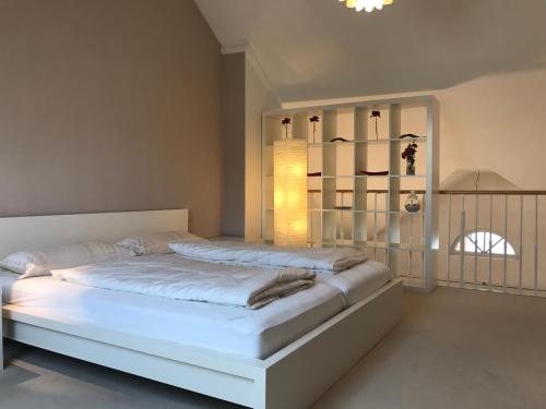 a bedroom with a large white bed in a room at Ferienwohnung am Hopfengarten - helle 2 Zimmer Maisonette mit großem Balkon in Lindau
