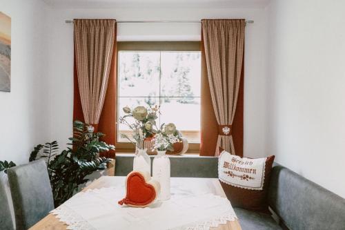 a dining room with a table and a window at Nedererhof - Zimmer Alpenrose mit Gemeinschaftsküche in Schmirn