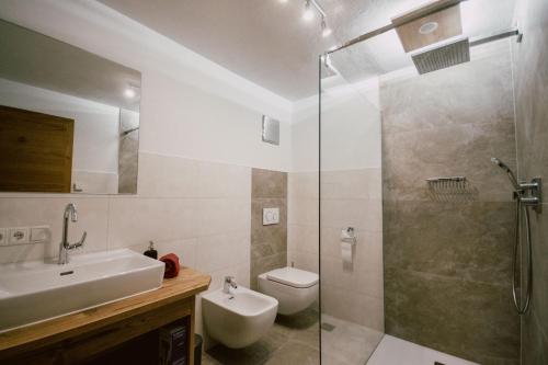 uma casa de banho com um chuveiro, um WC e um lavatório. em Nedererhof - Zimmer Alpenrose mit Gemeinschaftsküche em Schmirn