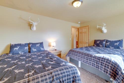 a bedroom with two beds with blue and white sheets at Custom Log Cabin with Views - 20 Mi to Yellowstone! in Island Park