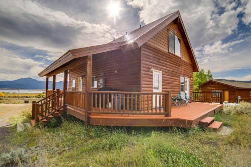 a log cabin with a porch and a deck at Custom Log Cabin with Views - 20 Mi to Yellowstone! in Island Park