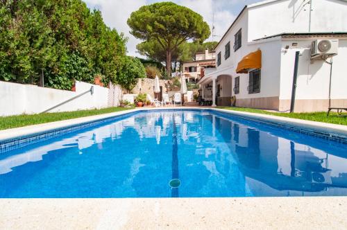 een zwembad met blauw water voor een huis bij Villa Nuis L'Estartit. Piscina y jardín privados. Ideal para familias in Torroella de Montgrí