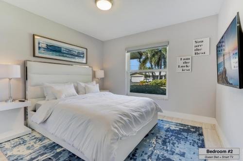 Un dormitorio blanco con una cama grande y una ventana en Canal - Water view, private pool, near beach, en Fort Lauderdale