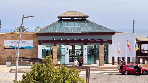 a building with a car parked in front of it at Caleta Dorada in Caleta De Fuste