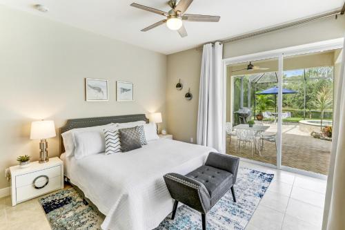 a bedroom with a bed and a chair and a patio at Modern home w screened pool, hot tub, & comm amenities! in Naples