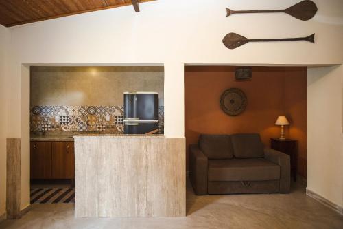 ein Wohnzimmer mit einem Sofa und einer Küche in der Unterkunft Solar da Teresa in Búzios