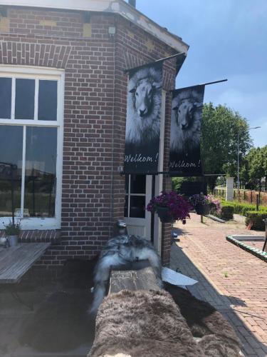 a dog laying on a bench in front of a building at Slapen bij de Brug in Zuidveld