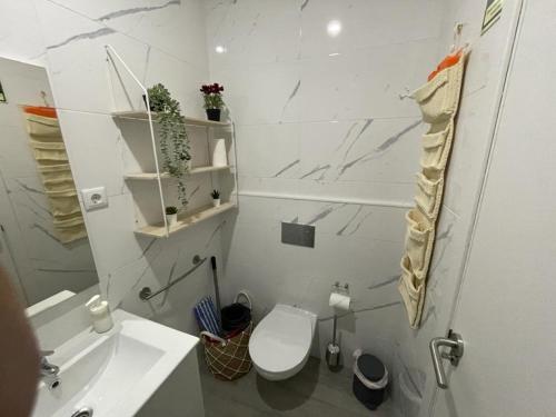 a white bathroom with a toilet and a sink at Stone Rose House in Nazaré