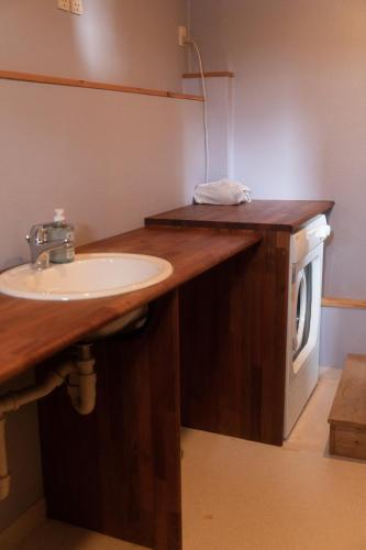 a bathroom with a sink and a washing machine at Cottage with stunning view of the sea and islands. in Leynar