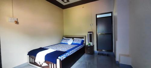 een slaapkamer met een bed met blauwe en witte kussens bij Costel in Malvan