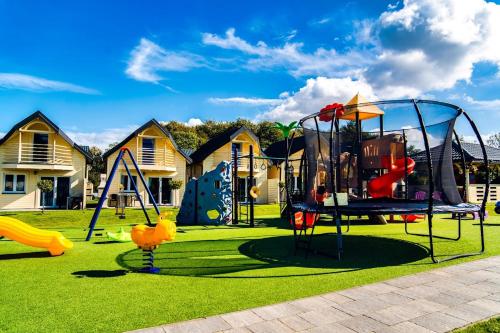 a park with a playground with slides and swings at Perłowe Wzgórze in Ustronie Morskie