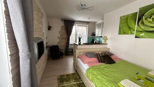 - une chambre avec un lit et une couverture verte dans l'établissement Bastien Studio near Airport, à Prague