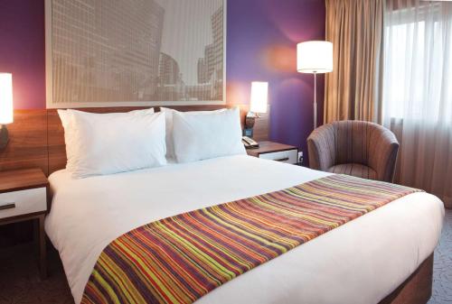 a hotel room with a large bed and a desk at Garden Court Sandton City in Johannesburg