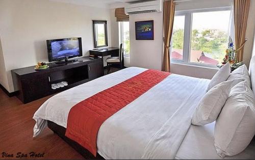 a bedroom with a large bed and a television at Việt Nam Hotel in Hue
