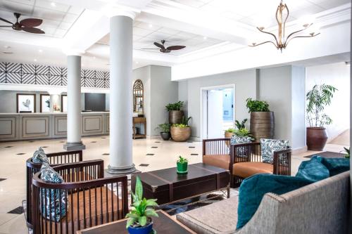 a lobby with couches and tables and plants at Southern Sun Ridgeway Lusaka in Lusaka