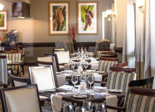 a dining room with tables and chairs with wine glasses at Southern Sun Ridgeway Lusaka in Lusaka