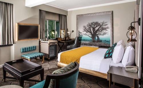 a hotel room with a large bed and a desk at Southern Sun Ridgeway Lusaka in Lusaka