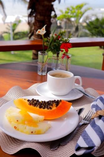 a plate of food and a cup of coffee on a table at Casa Cancun Hotel Boutique & Eventos in Penha