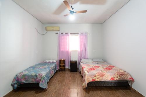 1 Schlafzimmer mit 2 Betten und einem Fenster in der Unterkunft Hostel toca do Noel e Bia in Várzea Grande