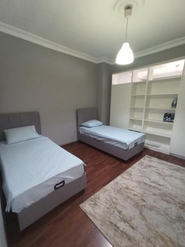 a bedroom with two beds and a rug at Dilaver-Apart in Istanbul