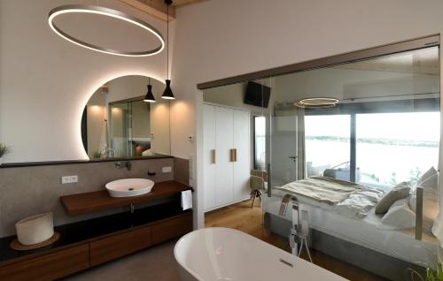 een badkamer met een bed, een wastafel en een spiegel bij Petit Chalet 69 - Am Hainer See in Neukieritzsch