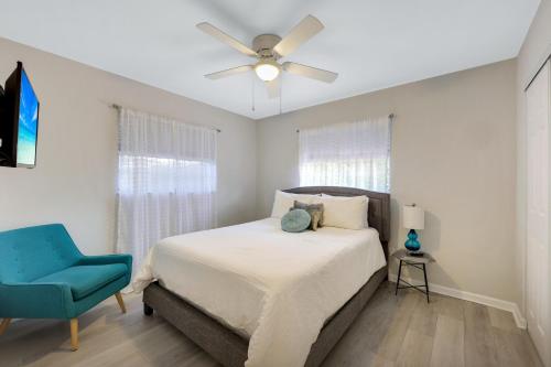 1 dormitorio con 1 cama con ventilador de techo y silla azul en Woodridge - Private Pool, Pet Friendly, 24 Hour Pro-Host Support, en Naples