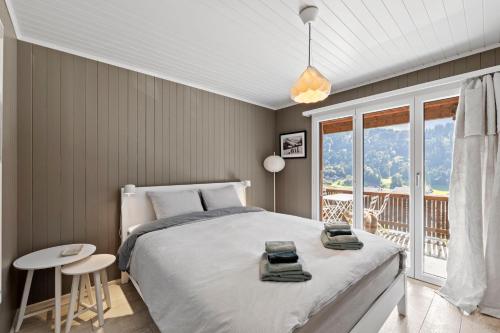 a bedroom with a large bed and a balcony at Sunny Design Chalet in Engelberg with spectacular view on Mount Titlis in Engelberg