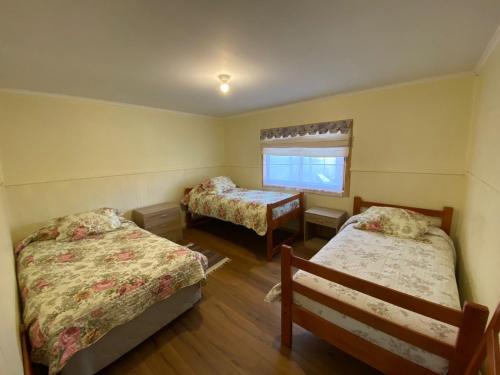 a small room with two beds and a window at Cabañas y Loft Entre Ríos y Lagos in Ranco