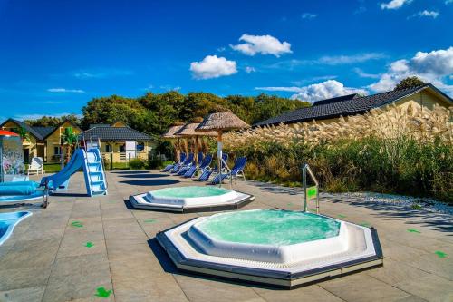 a pool with two jacuzzles and a slide at Perłowe Wzgórze in Ustronie Morskie