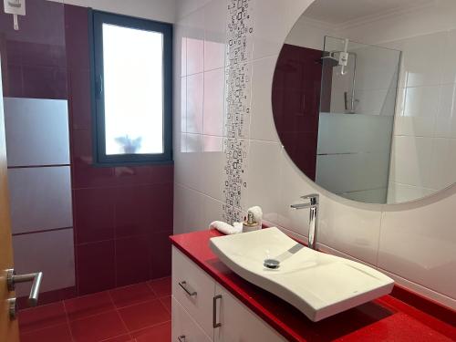 een badkamer met een witte wastafel en een spiegel bij Villa Livramento in Ponta do Sol