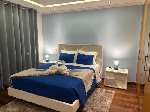 a bedroom with a large bed with blue sheets and blue pillows at Villa Livramento in Ponta do Sol