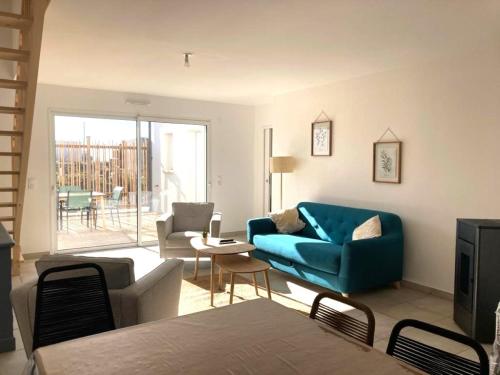 a living room with a blue couch and chairs at La Petite Marine a 150m de la plage in Brétignolles-sur-Mer