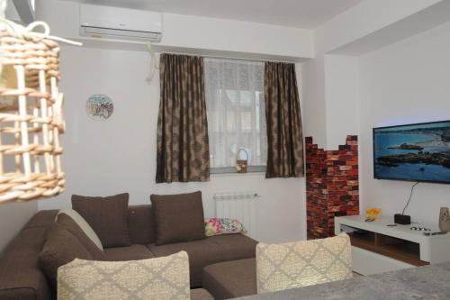a living room with a couch and a tv at King-size bed, Free parking, kitchenette, wifi apartments in Skopje