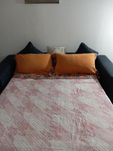 ein Bett mit orangefarbenem Kissen darüber in der Unterkunft Amalia B&b San francesco in Bari