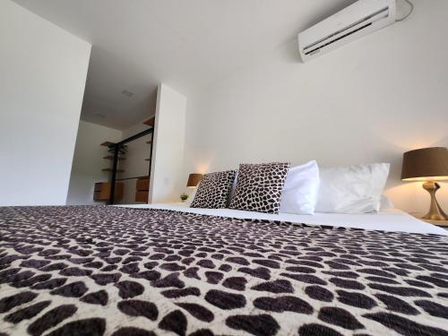 Schlafzimmer mit einem Bett mit einer schwarzen und weißen Bettdecke in der Unterkunft Amazonia Deluxe Lake Condo in Leticia