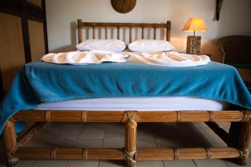 a bed with a blue blanket and pillows on it at Solar da Teresa in Búzios