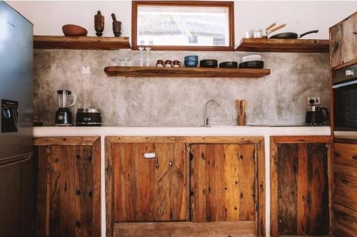 a kitchen with wooden cabinets and a sink at Ocean Front Villa with pool, Zanzibar in Pingwe