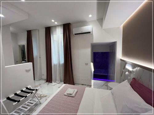 Habitación blanca grande con cama y TV. en ARIOSTO HOME, en Palermo