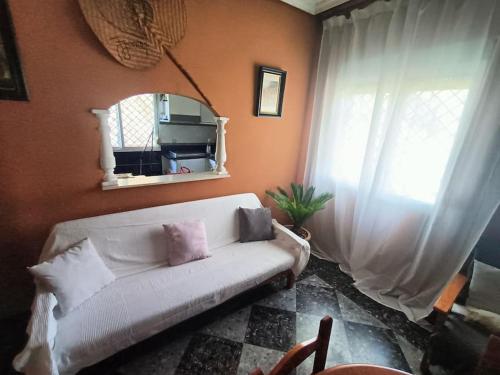 sala de estar con sofá blanco y ventana en Casa rural en el campo con animales, piscina y barbacoa, en Almodóvar del Río