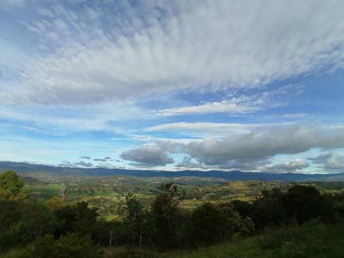 une vue sur une vallée sous un ciel nuageux dans l'établissement Mountain Cabin - Nature and Relax, à Fúquene