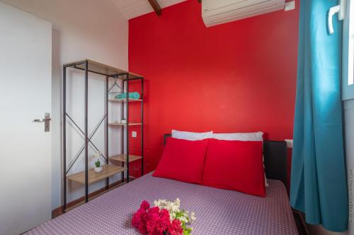a red bedroom with a bed with a red wall at 2 Bungalows avec Piscine et Evènements autorisés in Sainte-Marie