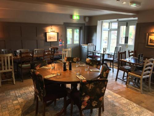 uma sala de jantar com uma mesa de madeira e cadeiras em Three Tuns Ashwell em Ashwell