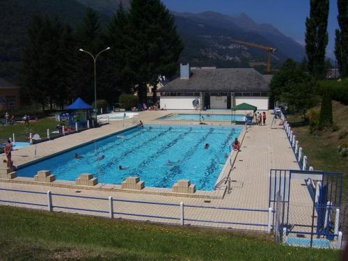 a large swimming pool with people in it at Hôtel Les Templiers in Luz-Saint-Sauveur