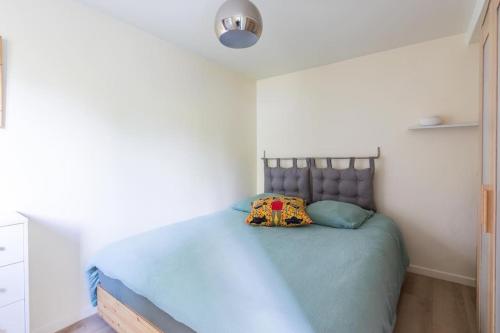 1 dormitorio con 1 cama con colcha azul en Maisonnette dans jardin partagé, en Colombes