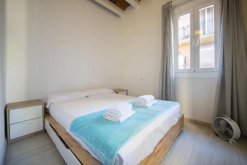 Catalunya Casas Lovely apartment central Barcelona 100m to beach! في برشلونة: غرفة نوم عليها سرير وفوط