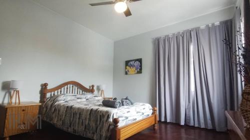 Un dormitorio con una cama y un ventilador de techo. en B&M, en Mendoza