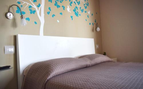 a bedroom with a bed with a tree painted on the wall at RE UMBERTO b&b - Suite di charme e Country rooms in San Salvo