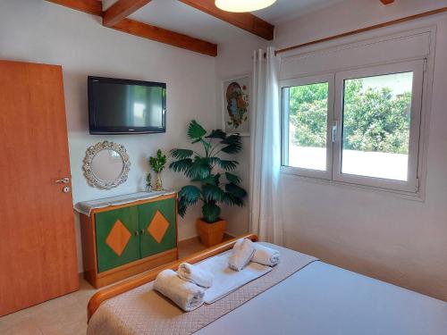 1 dormitorio con 1 cama, TV y ventana en Eva's House, Cozy Apartment in Traditional Village, en Pentamodi