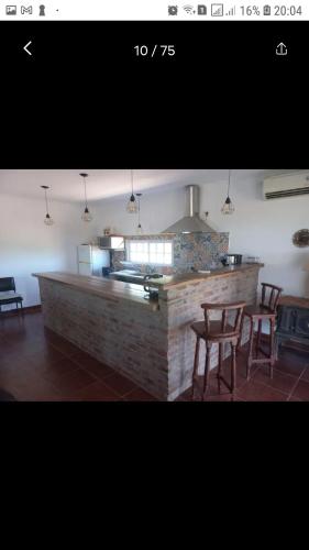 uma cozinha com um balcão, uma mesa e cadeiras em El retiro, casa de campo em San Antonio de Areco