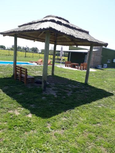 a large umbrella in the grass next to a pool at El retiro, casa de campo in San Antonio de Areco